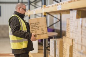 Crown Couriers warehouse assistant carrying box