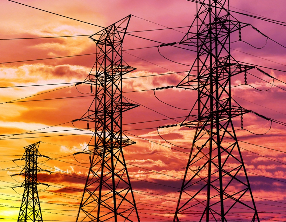 electricity pylons against sunset sky