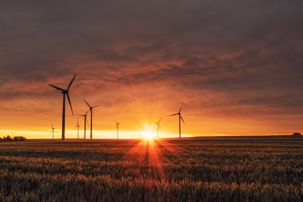 wind turbines in a field with sunsetting behid for utilities courier service