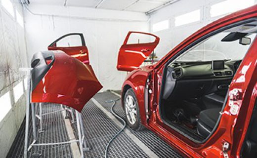 Automotive A luxury red car in a paint shop with its doors removed for a fresh coat of paint. High-quality photo