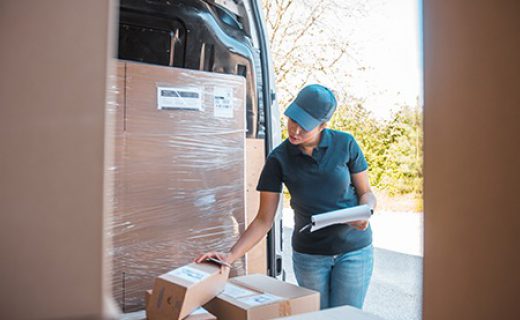 Mixed race female worker checking the labels on the packages inside the delivery van Mixed race female worker checking the labels on the packages inside the delivery van