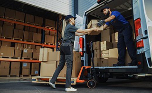 Outside of Logistics Distributions Warehouse: Diverse Team of Workers use Hand Truck Loading Delivery Van with Cardboard Boxes, Online Orders,  E-Commerce Purchases.