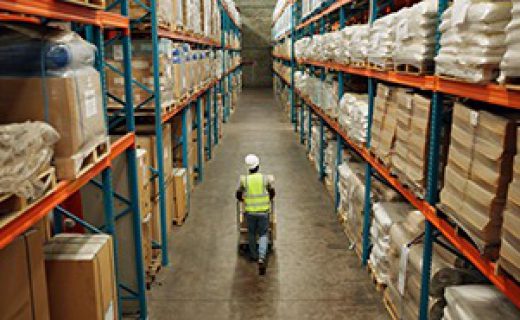 Warehouse, shipping and man walking in a distribution, freight and supply chain company. Worker, contractor and back with stock, factory and export business with employee working with storage